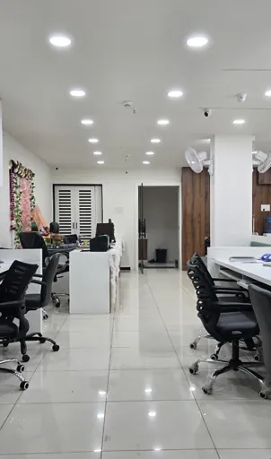 Bright open-plan office interior with workstations and recessed ceiling lights